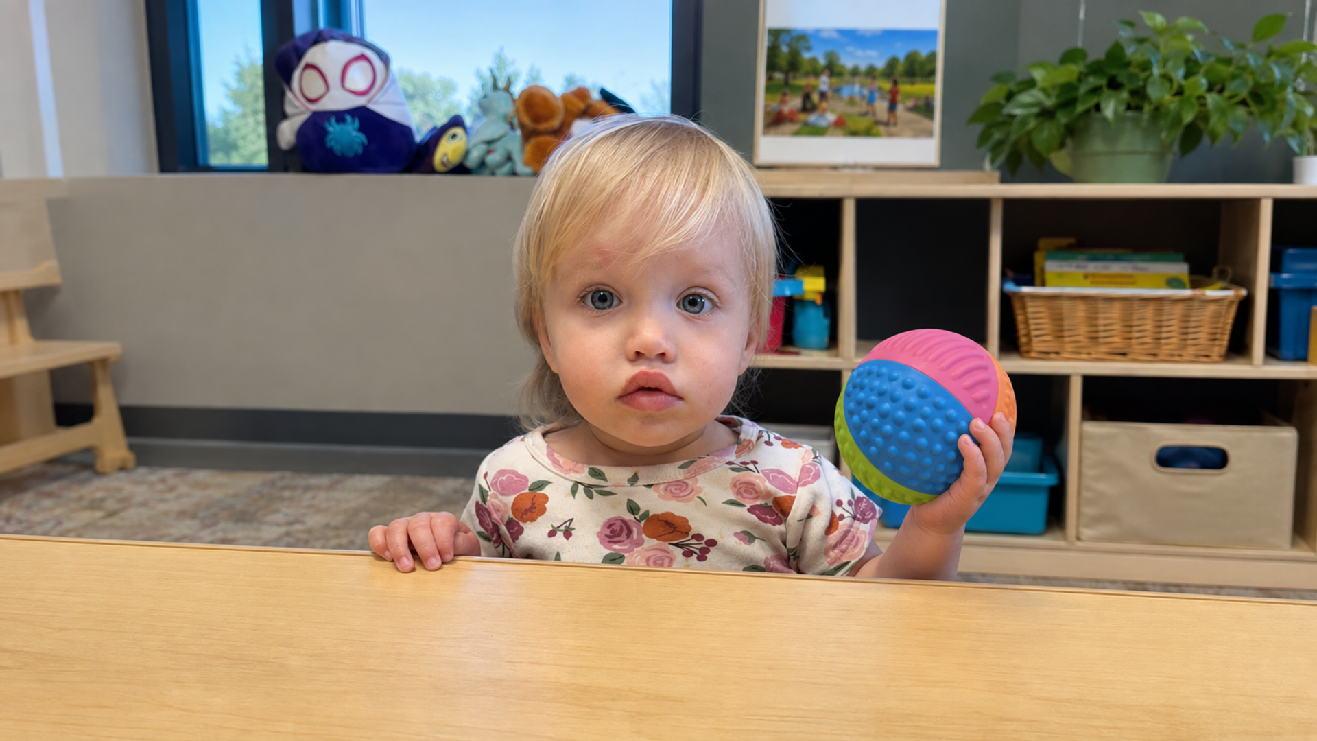 Toddler holding a colorful textured sensory ball