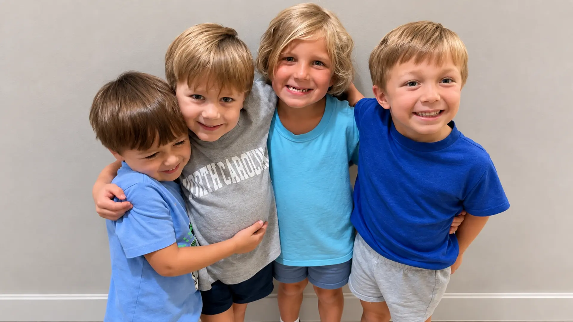 Four young friends smiling together at KinderKids Learning Center